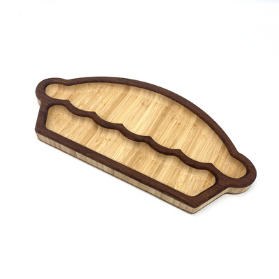 This image showcases a two toned wooden charcuterie board designed in the shape of a Pie, displayed against a white backdrop.